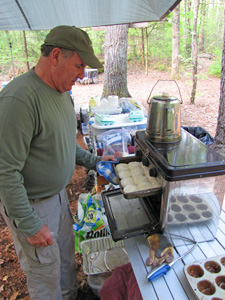 Steve pulls his made from scratch biscuits out of the camp oven